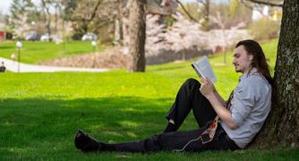 Image of person reading on campus.