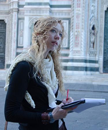 Photo of student walking and writing in Florence