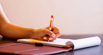 Image of a student writing on a piece of paper